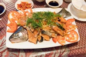 saumon frais alimentaire tranché avec légumes et sauce sur assiette photo