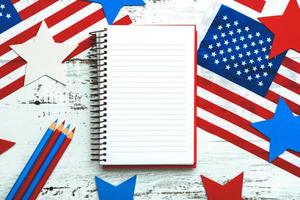 bonne fête de l'indépendance le 4 juillet. vue de dessus du carnet, des drapeaux américains, des étoiles et des crayons avec un espace pour le texte photo