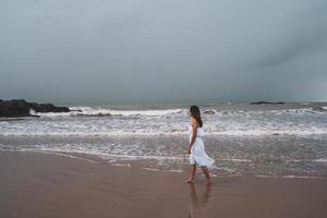 jeune femme se sentant seule et triste en regardant la mer par une journée sombre photo