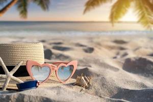 chapeau et lunettes de soleil sur la plage de sable tropicale avec espace de copie, concept de vacances d'été photo