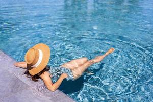 jeune femme voyageuse se détendre et profiter d'une piscine tropicale lors d'un voyage pour les vacances d'été, concept de voyage photo