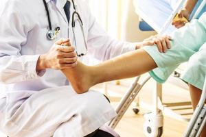 médecin et patient - médecin examinant la jambe du genou et de la cheville et entraînant un patient à la jambe cassée à l'hôpital - concept de physiothérapie