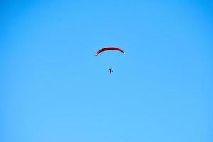 parachute motorisé dans un ciel bleu clair, vue aérienne de parachute motorisé, espace de copie de tourisme extrême photo