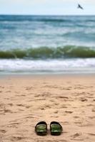 sandales sur la plage de sable, beau fond de la mer baltique, concept de noyade photo