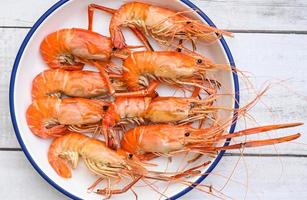 Assiette de fruits de mer Crevettes fraîches cuites sur fond blanc, crevettes crevettes servies sur une table de nourriture - vue de dessus de crevettes cuites au four photo