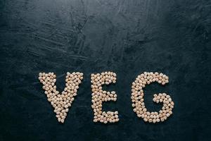 Garbanzo sec en forme de lettre pour les végétariens sur fond sombre avec espace de copie. concept d'aliments sains naturels. graines biologiques. vue de dessus photo