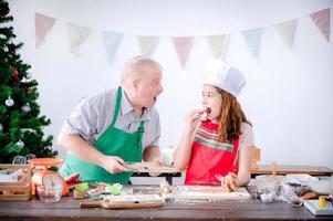 une jeune fille européenne et son père testent le pain d'épice qu'elle fait à noël et au nouvel an photo