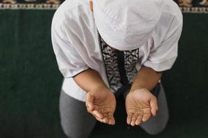 vue de dessus la main d'un musulman priant allah dans la mosquée photo