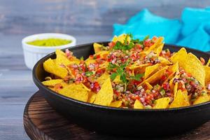 nachos mexicains au fromage. croustilles de maïs avec guacamole, salsa et ketchup. photo