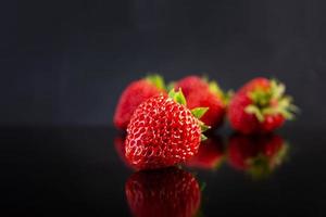fraise mûre fraîche douce isolée sur fond sombre. photo