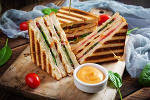 club sandwich avec jambon, tomate, fromage et épinards. panini grillé photo