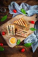 club sandwich avec jambon, tomate, fromage et épinards. panini grillé. vue de dessus photo
