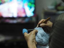 Main femme tricot fil bleu passe-temps bricolage fait main regarder la télévision tv photo