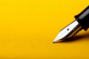 stylo plume sur fond jaune photo
