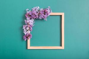 composition estivale ou printanière sur fond vert. fleurs lilas avec carré en bois avec vue de dessus de l'espace de copie. été, concept floral de printemps. photo