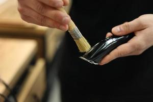 l'homme nettoie une tondeuse à cheveux électrique, une brosse de tondeuse au salon de coiffure. notion de beauté photo