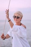 belle femme heureuse blonde appréciant le coucher du soleil sur le yacht dans la mer. voyage, aventure, concept de détente photo