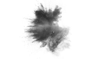 explosion de poudre noire. les particules d'éclaboussures de charbon de bois sur fond blanc. gros plan d'éclaboussures de particules de poussière noire isolées sur fond. photo