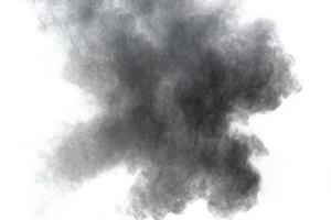 explosion de poudre noire sur fond blanc. éclaboussures de particules de poussière noire. photo