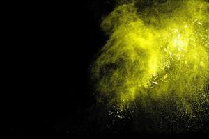 explosion de poudre de couleur jaune sur fond noir. photo