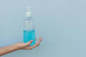 femme tenant un gel d'alcool à la main pour se laver prévenir les virus et les bactéries photo
