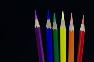 crayon, symbole de couleur de la fierté lgbt, sur fond noir. photo