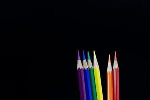 crayon, symbole de couleur de la fierté lgbt, sur fond noir. photo