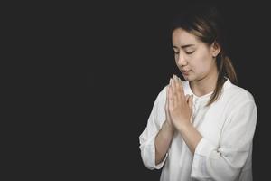 une femme croisa les mains, priant pour les bénédictions et priant Dieu. prier pour les croyances spirituelles. le pouvoir de l'espoir ou de l'amour et de la loyauté. foi en la bonté. photo