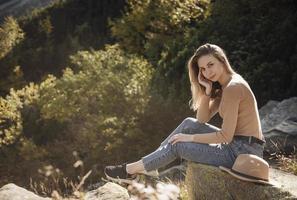 jeune femme en randonnée assise sur un rocher photo