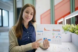 jeune femme d'affaires sur le lieu de travail et lisant du papier au bureau photo