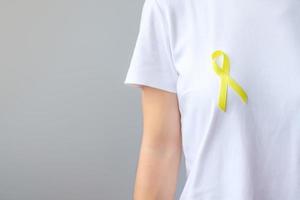 ruban jaune pour soutenir les personnes vivant et malades. journée de prévention du suicide de septembre, concept de mois de sensibilisation à l'enfance, au sarcome et au cancer des os photo