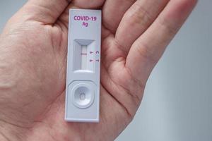 homme tenant un kit de test d'antigène rapide avec un résultat négatif lors du test covid-19 sur écouvillon. coronavirus auto-test nasal ou à domicile, concept de verrouillage et d'isolement à domicile photo