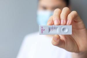 femme tenant un kit de test d'antigène rapide avec un résultat négatif lors du test covid-19 sur écouvillon. coronavirus auto-test nasal ou à domicile, concept de verrouillage et d'isolement à domicile photo