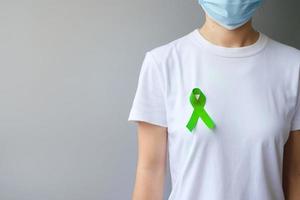 septembre lymphome mondial et octobre mois de sensibilisation à la journée de la santé mentale, femme avec ruban vert citron pour soutenir les personnes vivant et malades. notions de soins de santé photo