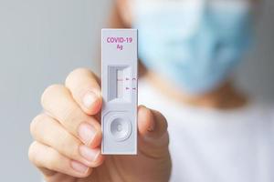 femme tenant un kit de test d'antigène rapide avec un résultat négatif lors du test covid-19 sur écouvillon. coronavirus auto-test nasal ou à domicile, concept de verrouillage et d'isolement à domicile photo