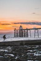 homme jouant au football sur la plage au coucher du soleil. photo