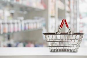 panier vide sur le comptoir de la pharmacie de la pharmacie avec des étagères floues de médicaments et de suppléments de vitamines photo