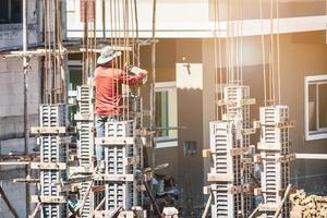 travailleur versant du béton sur le coffrage sur le chantier de construction de la maison de construction photo