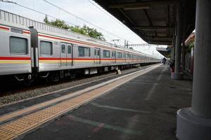 train de la ligne de banlieue arrive à une gare de la gare, jakarta. photo