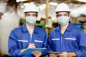 les hommes de l'industrie portent un masque facial pendant le service travaillant en usine pour prévenir la pollution par la poussière de l'air du virus covid-19 et pour une bonne santé. photo