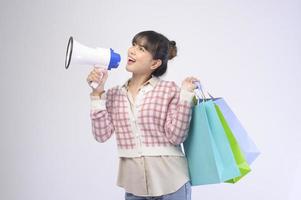 Attractive shopper woman holding shopping bags sur fond blanc photo