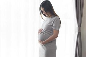 belle jeune femme enceinte à la maison, concept de soins de maternité et de grossesse photo