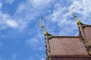 Le toit rouge d'un temple thaïlandais avec un sommet à pignon est un art thaïlandais délicat créé par des artisans qualifiés. et dans tous les temples thaïlandais, c'est le même art dans le ciel bleu par une journée ensoleillée. photo