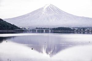 le reflet de la belle montagne fuji avec un pont dans le lac en été, le célèbre point de repère et lieu d'attraction des touristes qui passent de longues vacances au japon, le lac kawaguchiko photo