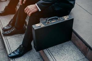 hommes d'affaires avec bagages assis pour penser quelque chose dans les escaliers. photo