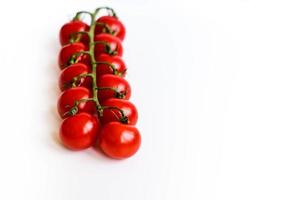 De délicieuses tomates cerises rouges fraîches sur fond blanc. agriculture d'été. cousine italienne.shallow dof, image de mise au point sélective. photo