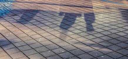 Ombres de personnes dans une zone commerciale européenne sur un sol pavé photo