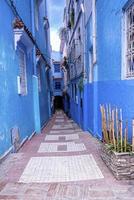 ruelle étroite de la ville bleue avec des structures résidentielles des deux côtés photo