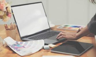 jeune photographe et graphiste au travail au bureau. moniteur d'écran vide pour le montage d'affichage graphique. photo