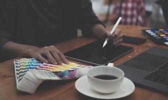 jeune photographe et graphiste au travail au bureau. moniteur d'écran vide pour le montage d'affichage graphique. photo